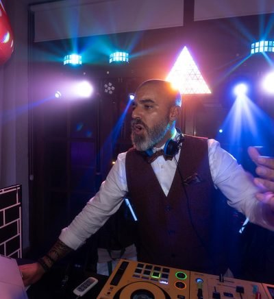 jonay-diaz-dj-bodas-santa-cruz-tenerife Jonay Díaz DJ señalando hacia la cámara en un entorno exterior con vegetación tropical de Tenerife.